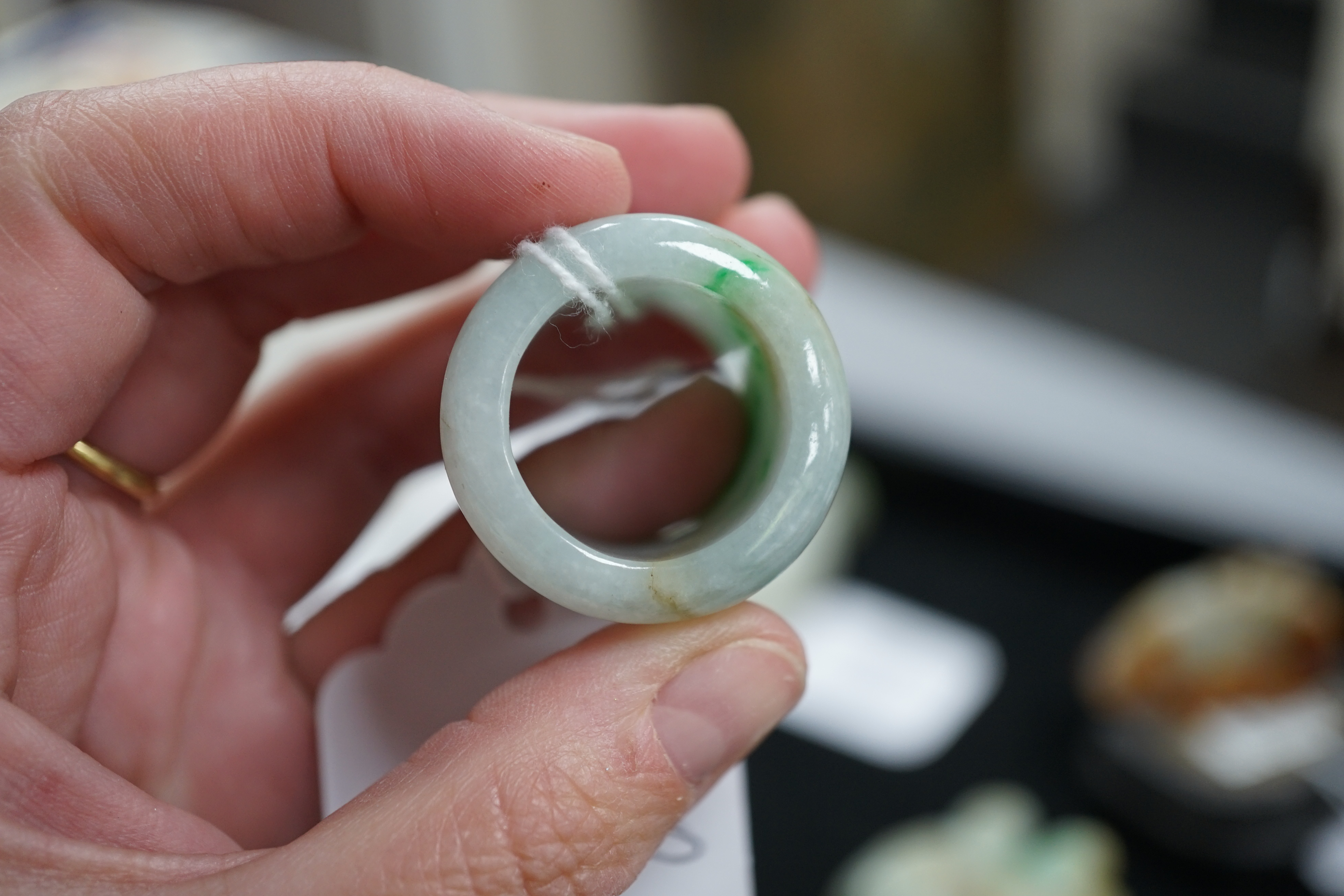 A Chinese jadeite archer's thumb ring, wood stand and cover, 19th century